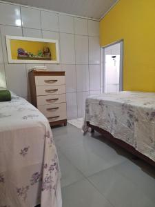 a bedroom with two beds and a dresser in it at Casa da Lia in Lençóis