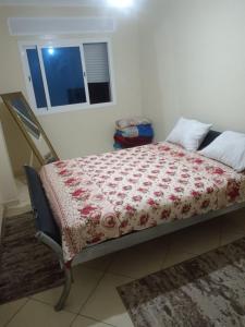 a bedroom with a bed with a red blanket at Appart hôtel tanger in Oulad Akkou +6 photos