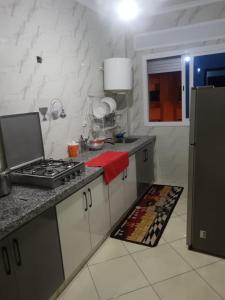 a kitchen with a stove and a red towel at Appart hôtel tanger in Oulad Akkou