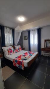 a bedroom with a large bed with blue curtains at Les hauts de bellevue in Bouillante
