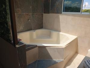 a white bath tub in a bathroom with a window at Alojamiento Independiente vipasa in Cali