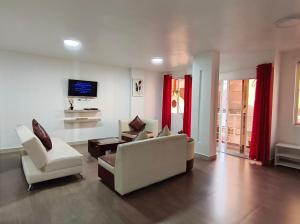 巴尼奥斯Casa Gaviota Dorada的有两把椅子和一台电视的客厅