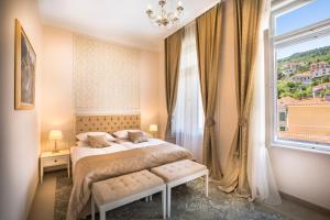 a bedroom with a bed and a large window at Hotel Bellevue - Liburnia in Opatija
