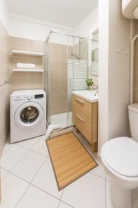 a bathroom with a washing machine and a toilet at Studio le Colibri, Entre terre et mer, vue incroyable, citerne in Le Gosier