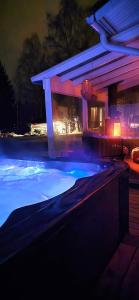 a swimming pool at night with purple lights at Villa It's Arctic Magic! in Rovaniemi