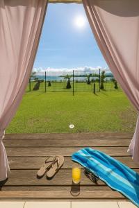 a pair of sandals and a glass of orange juice on a wooden deck at Studio le Colibri, Entre terre et mer, vue incroyable, citerne in Le Gosier