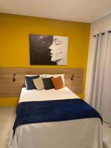 a bedroom with a large bed with a painting on the wall at Loft com 2 Qts e garagem em área nobre in Sinop
