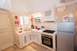 a small kitchen with white cabinets and a refrigerator at Luxury Villas Hariton in Emporio