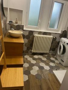 a bathroom with a sink and a radiator at Maison de plain pied - 120m2 - Location cure ou vacances in Bagnoles de l'Orne