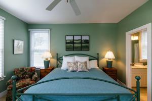 a green bedroom with a bed and a chair at Tequila Sunset in Edisto Island