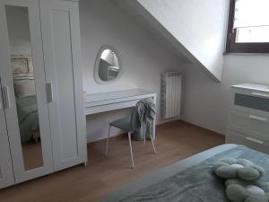 a bedroom with a desk with a mirror and a chair at La Fenice in Mortara