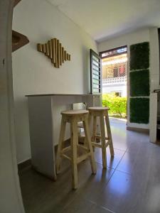 a kitchen with two wooden stools and a counter at BORA - Apto 101Tu espacio fuera de casa in Ibagué