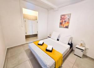 a white bedroom with a bed and a window at Les Terrasses de la Wallon Paprika in Les Trois-Îlets