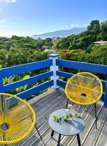 two chairs and a table on a deck at Les Terrasses de la Wallon Paprika in Les Trois-Îlets
