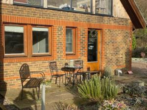 a patio with chairs and a table in front of a brick building at Carpenters-stay in Dorking