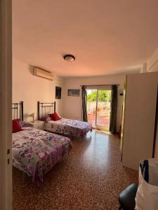 a room with two beds and a sliding glass door at Apartamento Isabel in Denia