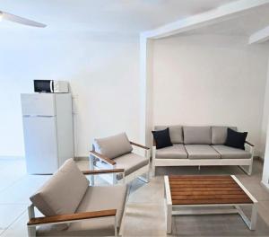 a living room with two couches and a refrigerator at Les Terrasses de la Wallon Paprika in Les Trois-Îlets