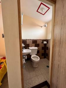 une salle de bain avec toilettes et lavabo dans l'établissement Hostal Color Inn, à Santo Domingo Tehuantepec