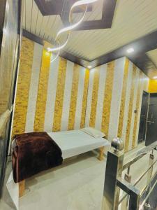 a bed in a room with yellow and white stripes at My Perfect Stay in Ayodhya
