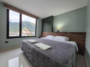 Un dormitorio con una cama grande con dos toallas encima. en Apartment 7 with Jacuzzi in the center - 3 Bedroom 2 Bath, en Baños 13 fotos más