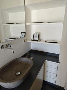 a bathroom with a large sink and white shelves at Garibaldi 23 in Arezzo