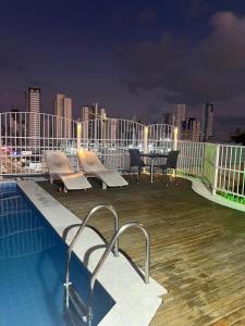 a rooftop deck with a pool and table on a building at Manaíra Flat 206 Em frente ao shopping Manaíra in João Pessoa