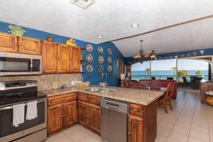 a kitchen with wooden cabinets and a view of the ocean at Sonoran Spa W409 in Campo del Medio