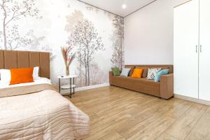 a bedroom with a bed and a couch at ALMA PARK Apartments 326 in Taldykolʼ