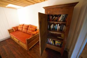 a room with a book shelf and a couch at Gite des deux fontaines in Samoëns