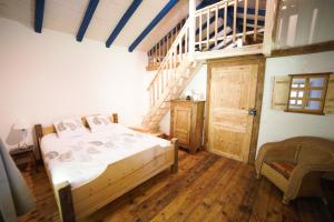 a bedroom with a bed and a wooden staircase at Gite des deux fontaines in Samoëns