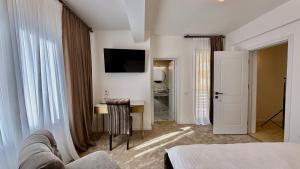 a hotel room with a bed and a desk and a television at Jolie Boutique Hotel in Craiova