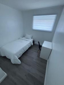 Un dormitorio con una cama y una mesa y una ventana. en Place to stay in Gatineau, en Gatineau