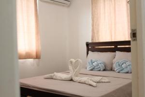 1 Schlafzimmer mit 2 Handtüchern auf einem Bett in der Unterkunft Holiday Home in Bacolod City, Philippines in Bacolod City + 38 Fotos