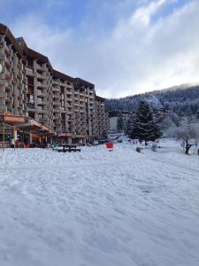 a snow covered parking lot in front of a hotel at Studio Villard-de-Lans in Villard-de-Lans