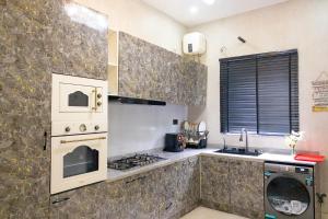 a kitchen with a stove and a stove top oven at D'Vista Apartments in Ikota