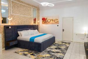 a bedroom with a bed with a blue and white blanket at D'Vista Apartments in Ikota