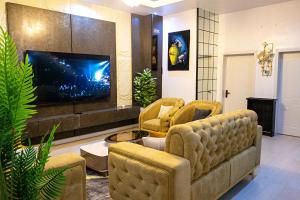 a living room with two couches and a flat screen tv at D'Vista Apartments in Ikota