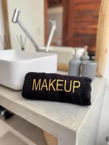 a bathroom counter with a sink and a black and gold make upvisor at Casa Calango suites in Fortim +44 photos
