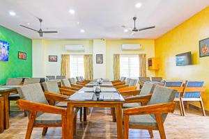 una sala da pranzo con un lungo tavolo e sedie di Townhouse Oak Dwarakanagar Port Stadium a Maddilapālem