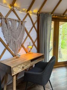 a wooden desk in a room with a chair at Jurta nad Zegrzem z prywatnym jacuzzi in Arciechow +14 photos