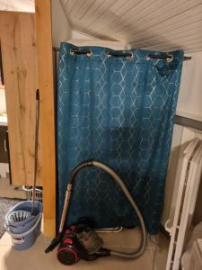a vacuum cleaner sitting next to a blue shower curtain at bien-être in Bourg-sur-Gironde +20 photos