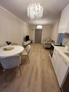 a kitchen and living room with a table and chairs at Apartament Iulius Mall Cluj in Cluj-Napoca