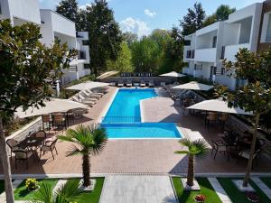 an outdoor pool with tables and chairs and umbrellas at Hotel Halibas in Ulcinj