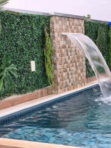 a swimming pool with a water fountain in a building at Casa Boituva in Boituva