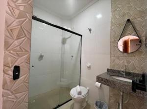 ein Badezimmer mit Dusche, Toilette und Waschbecken in der Unterkunft Hotel Carmelita in Aparecida