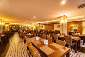 un restaurante con mesas y sillas de madera en Anbessedor Hotel All inclusive, en Antalya