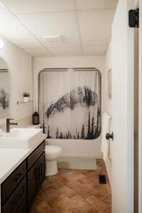a bathroom with a shower curtain with a mountain at Hot-tub, Games Room, Walk-in Sauna, 7 BM, 15 mins to Waterton in Mountain View