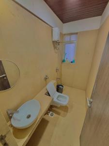 a bathroom with a white toilet and a sink at prahi villa 3bhk in Lonavala