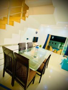 a dining room with a glass table and chairs at prahi villa 3bhk in Lonavala