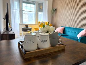 a tray with coffee cups on top of a table at Falkirk City Centre Stylish Two-Bedrooms Apartment in Falkirk